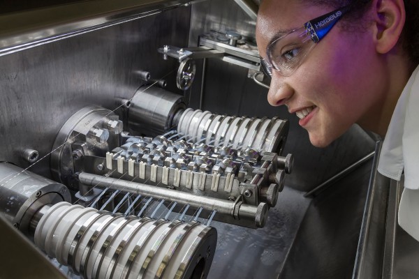 The employee at the fine wire drawing machine checks the position of the drawing die for the straightness of the probing wire